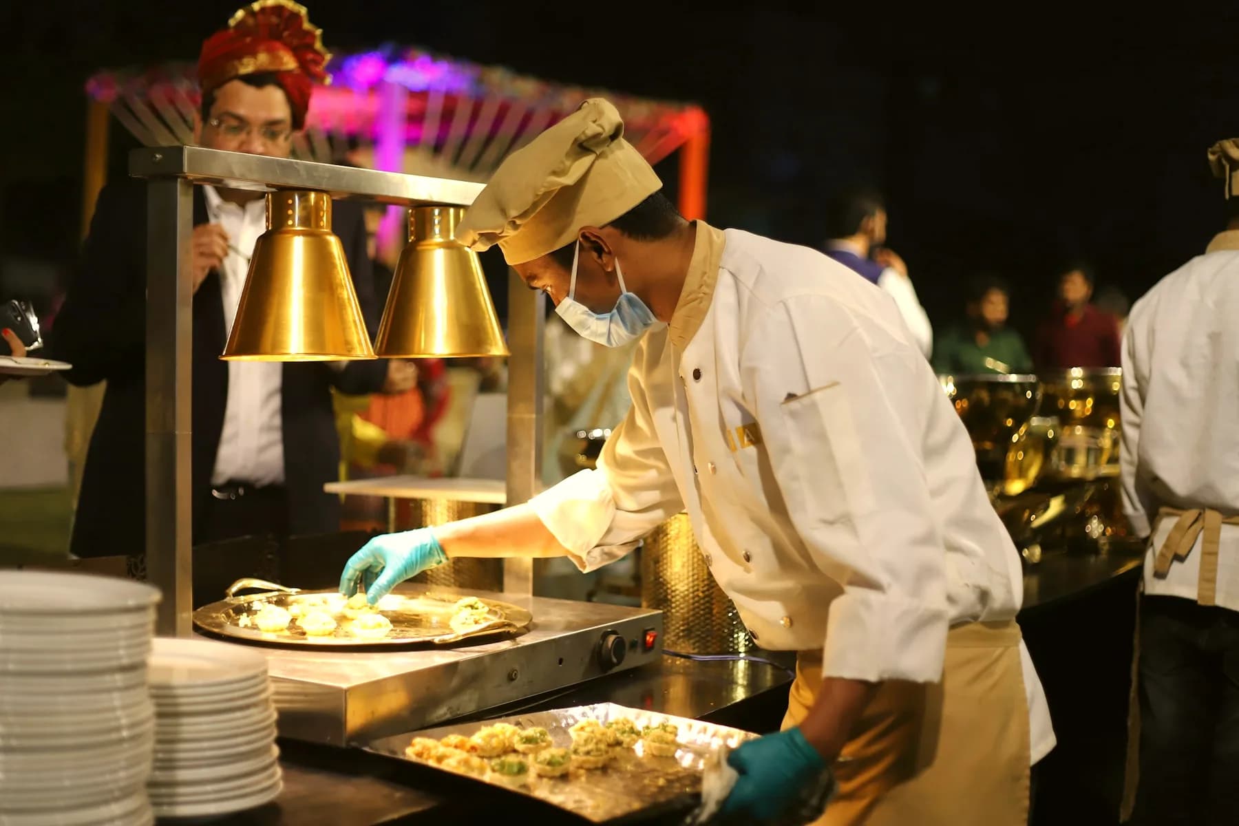 A chef plating food at the kitchen pass