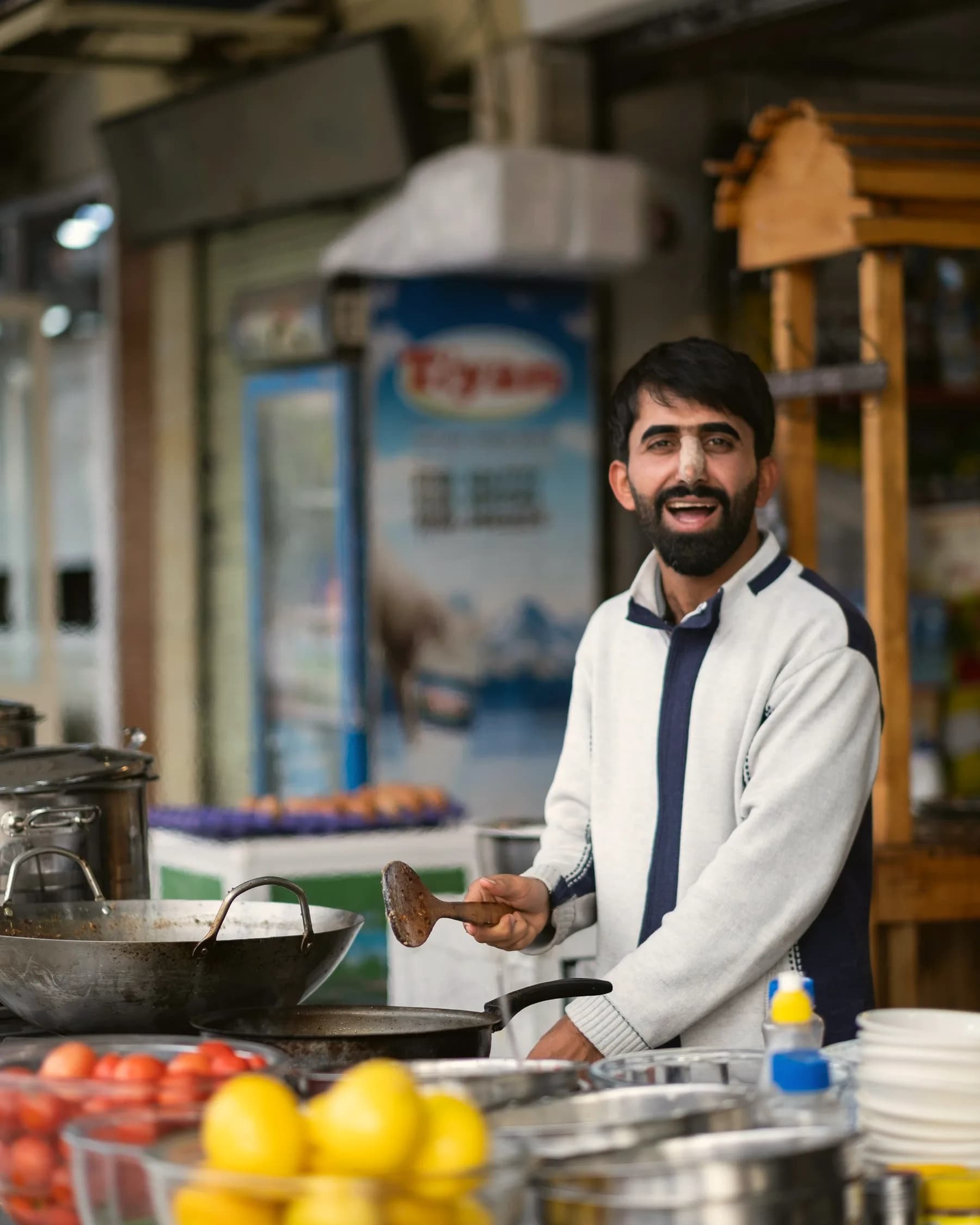 A smiling cook at an Indian food counter