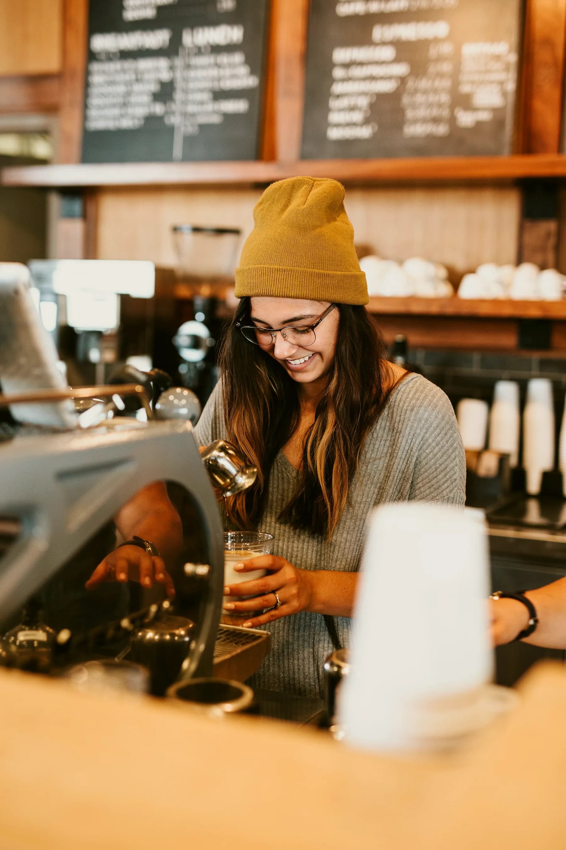 A smiling barista making a drink