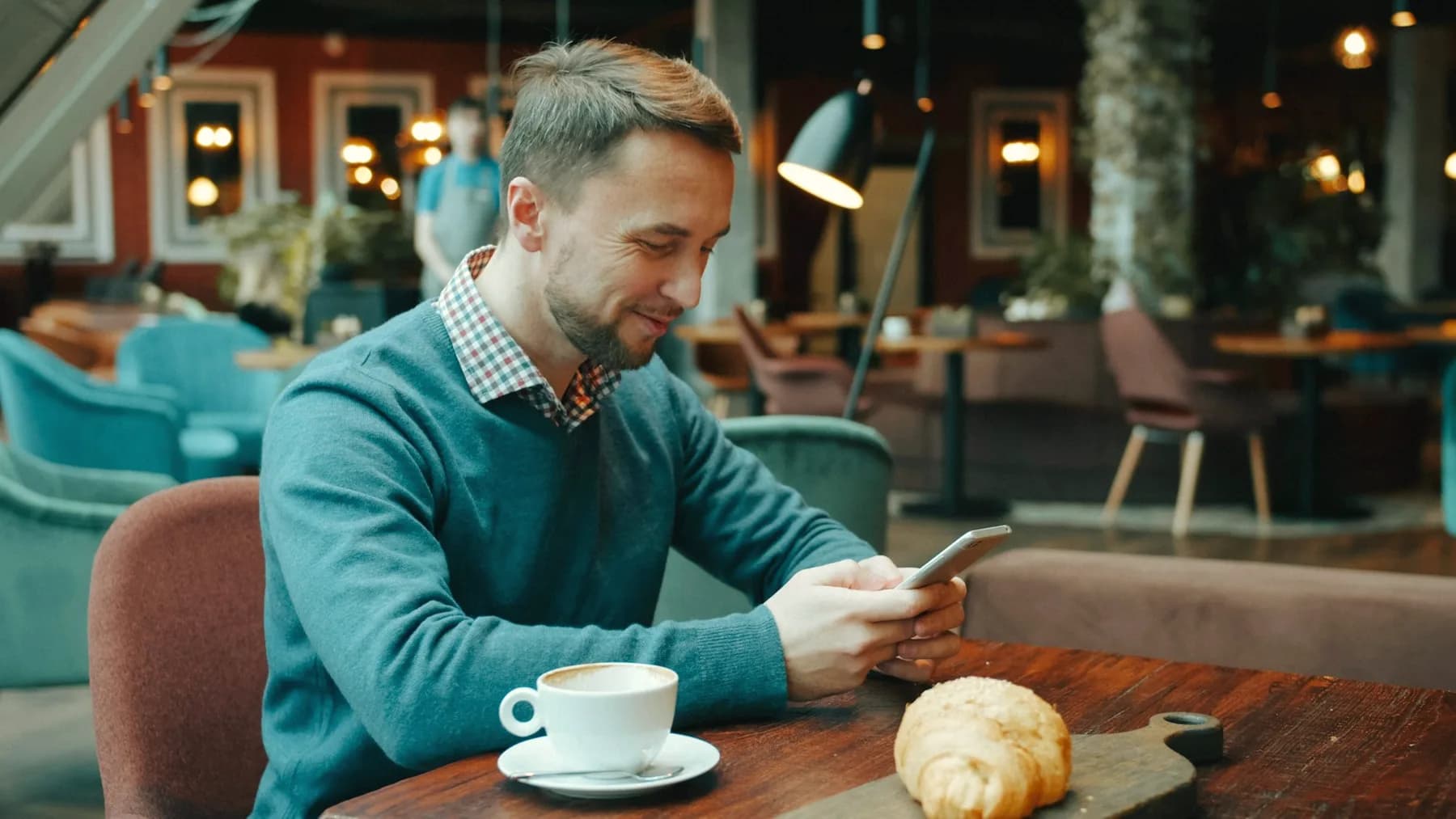 A restaurant owner checking sales on his phone